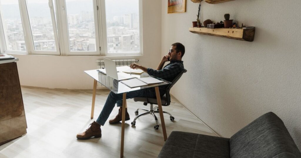 Man working at a laptop at a home desk, comparing Remote.com alternatives for hiring in Asia